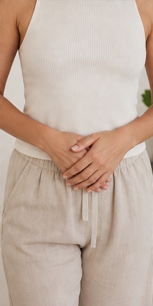 Detalhe feminino com as mãos próximas à região abdominal